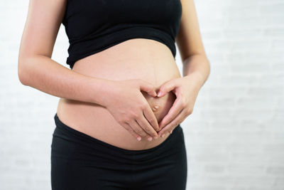 Midsection of pregnant woman touching stomach