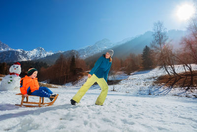 Rear view of man walking on snow covered mountain