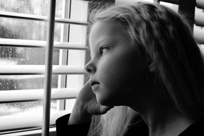 Close-up of woman looking through window