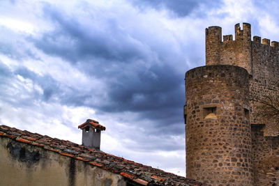 Low angle view of old building against cloudy sky