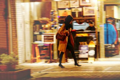 Woman standing in illuminated city at night