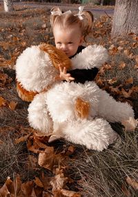 High angle view of cute girl with toy sitting on grass