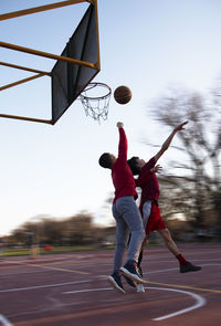 Basketball players jumping to catch the ball