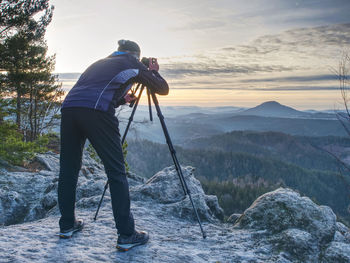 Hiker admiring the stunning misty mountain range, sunny morning. epic travel in a wilderness,