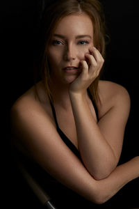 Portrait of a beautiful young woman over black background