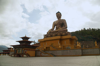 Statue against temple building against sky