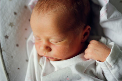 Newborn baby sleeps peacefully. gentle innocent baby lies  closeup portrait at home, top view