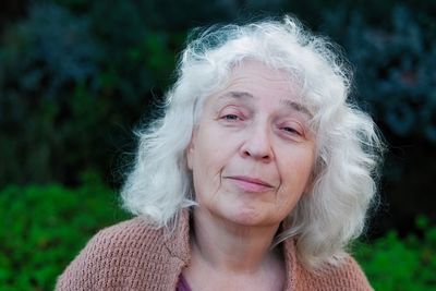 Closeup portrait of skeptical senior lady, woman looking suspicious. beautiful curly gray hair.