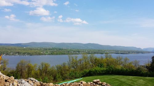 Scenic view of lake by mountains against sky