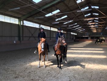 People riding horse in stable