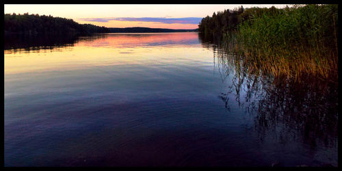 Scenic view of calm lake at sunset