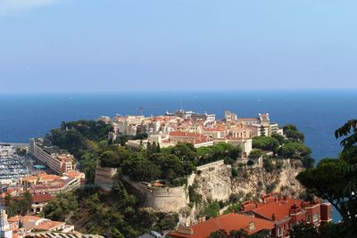 High angle view of townscape by sea against sky