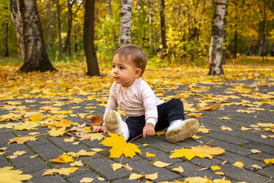 Full length of boy sitting on field