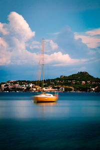 Sailboats in sea against sky