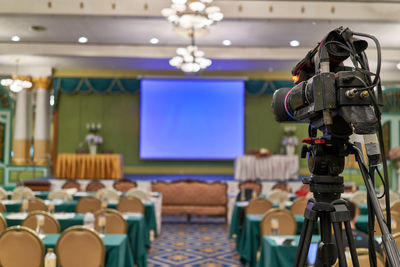 View of camera with tripod in room at conference event