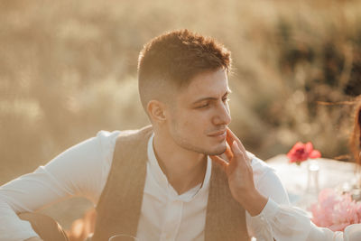 Portrait of young man looking away outdoors