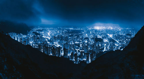 High angle view of illuminated city against sky at night