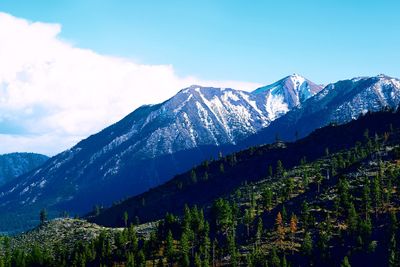 Low angle view of mountains against sky on sunny day during winter