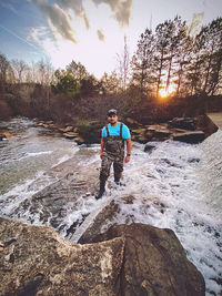 Man standing on rock against sky