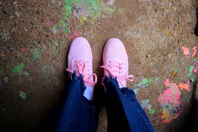 Low section of person standing on pink shoes