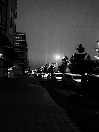 Cars on road amidst buildings in city at night