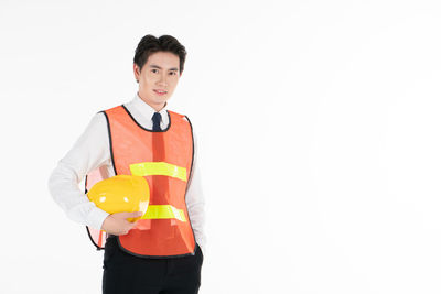 Portrait of young man standing against white background