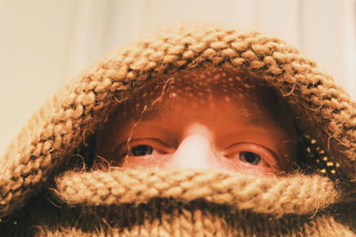 Close-up of man covering face with sweater