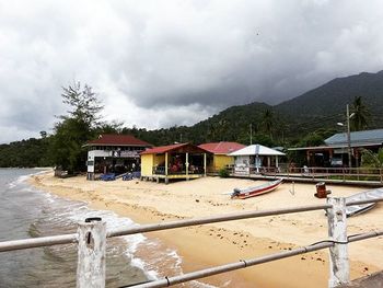 Houses on mountain against cloudy sky