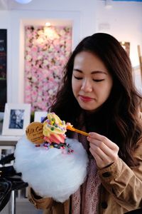 Beautiful young woman holding candy