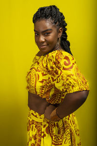 Close-up portrait of young, serious, beautiful woman, looking at camera, wearing colorful clothes. 