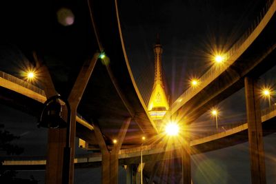 Low angle view of illuminated bridge against sky at night