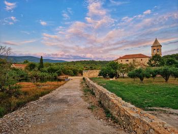 Road amidst field against sky
