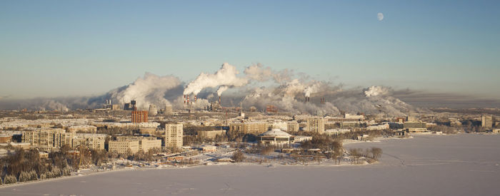 Smoke emitting from factory against clear sky