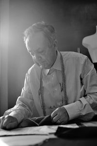 Midsection of man holding paper while sitting on table