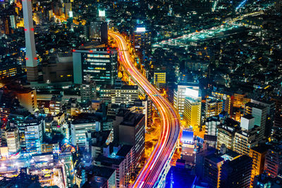 Aerial view of highway amidst buildings in city at night