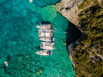 High angle view of anchored sailing boats in blue bay near sea caves in paxos greece.