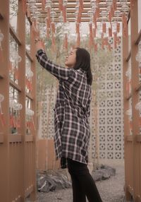 Rear view of woman standing against wall