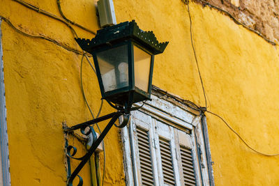 Low angle view of yellow light mounted on wall