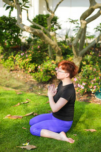 Side view of woman sitting on grass