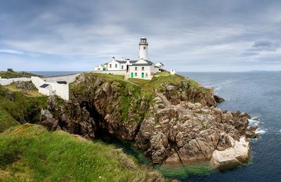 Lighthouse in ireland with sea an sky backdrop