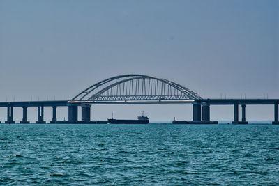 Bridge over sea against clear sky