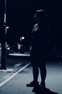 Woman standing on street at night