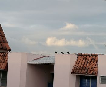 Roof of building against cloudy sky