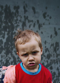 Little boy boy not happy with rain, funny face, wet child outdoors