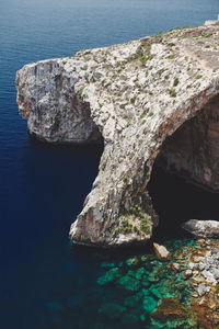 Rock formations in sea at the blue grotto on malta