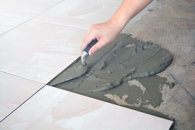 High angle view of person applying concrete on floor