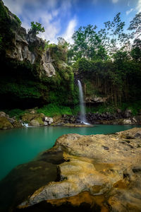 Scenic view of waterfall against rocks