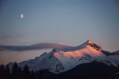 Scenic view of snowcapped mountains against sky during sunset