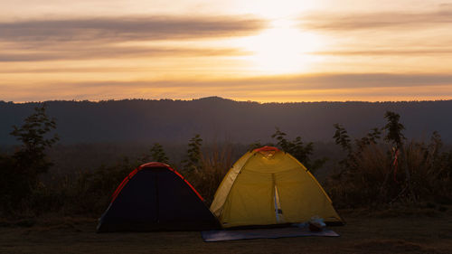 Scenic view of tent against sky during sunset