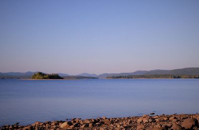 Scenic view of lake against clear blue sky